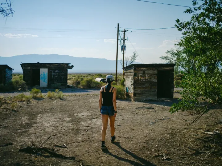 Person standing in an open lot beneath a bright sky