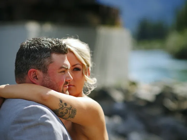 Newlyweds resting together near the water after the ceremony