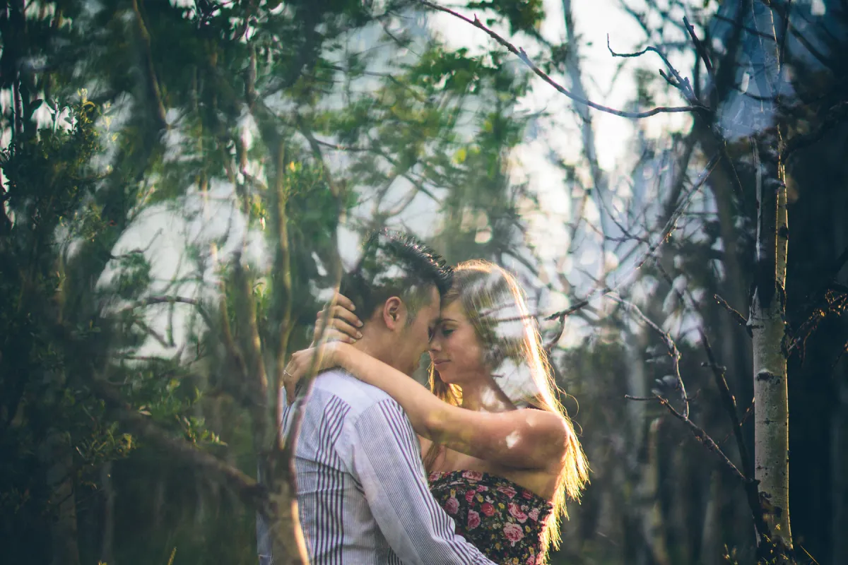 Couple embracing in birch woods during an Alberta engagement session