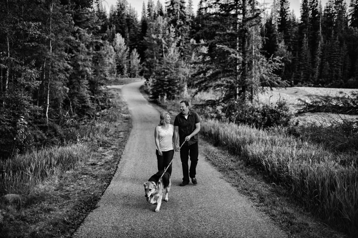 Black and white photo of a couple walking on a country road during an engagement session