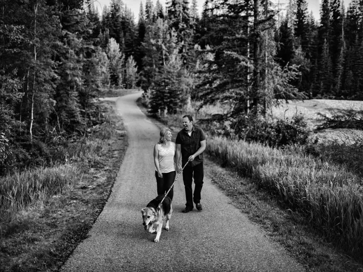 Black and white photo of a couple walking on a country road during an engagement session