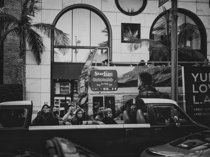 Black-and-white city scene with people visible through a bus window