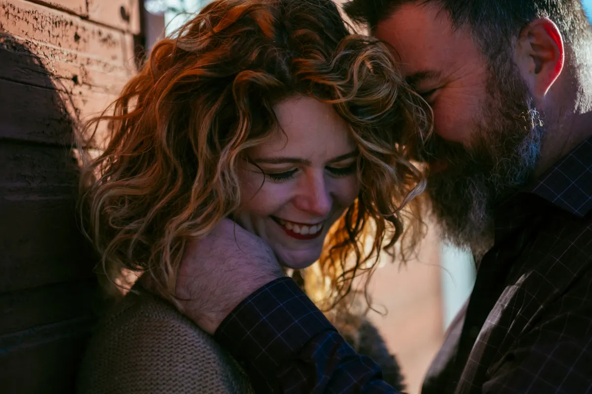 Couple laughing closely together during a candid engagement session