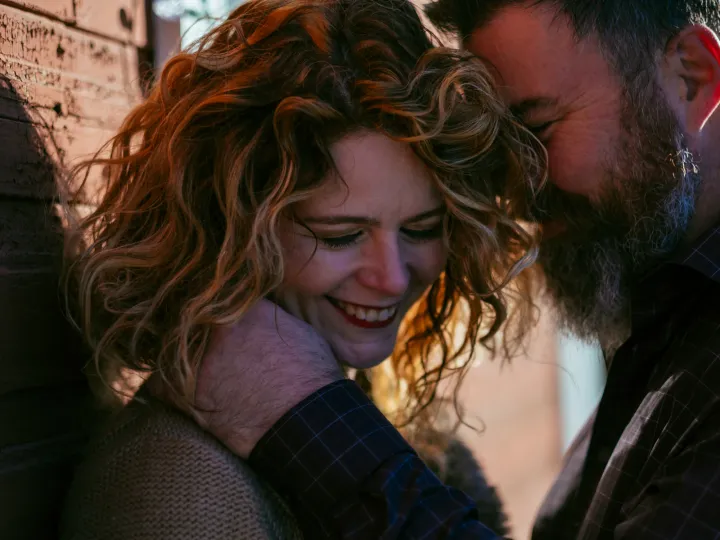 Couple laughing closely together during a candid engagement session