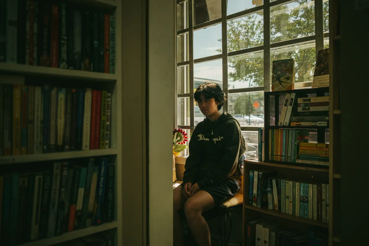 Quiet portrait near a window and shelves in warm interior light
