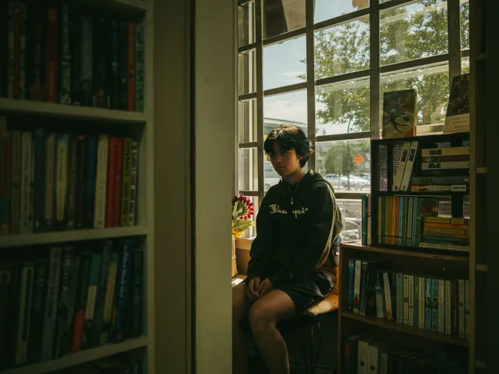 Quiet portrait near a window and shelves in warm interior light