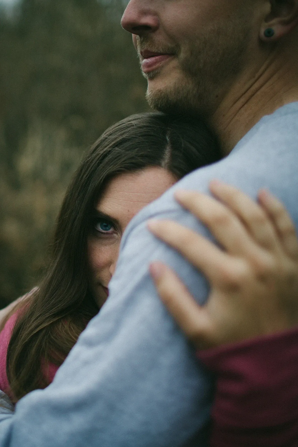 Close portrait of a woman looking over her partner shoulder during an engagement session