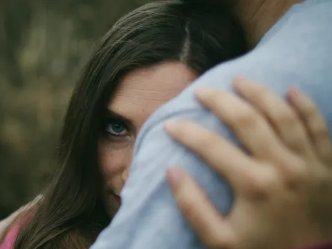 Close portrait of a woman looking over her partner shoulder during an engagement session