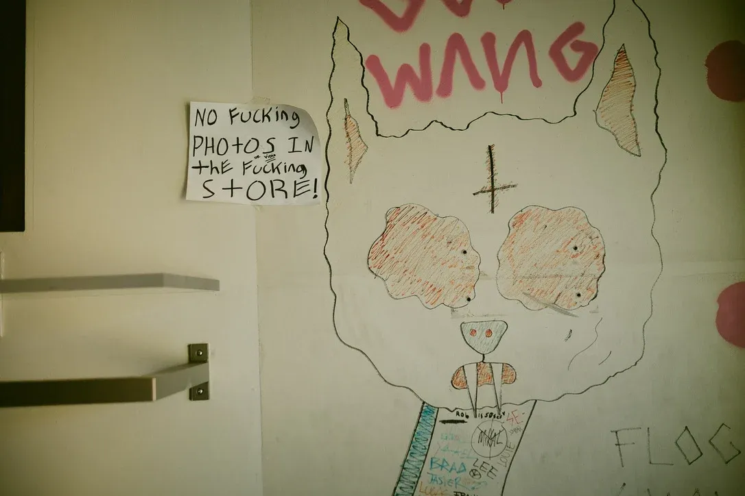 Childlike drawing and handwritten note on an interior wall