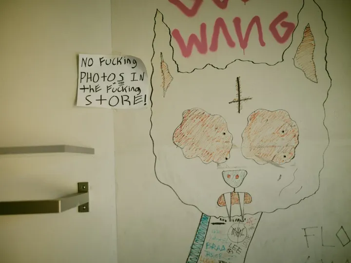 Childlike drawing and handwritten note on an interior wall