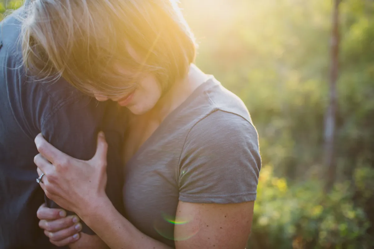 Couple embracing closely in golden hour light during an engagement session
