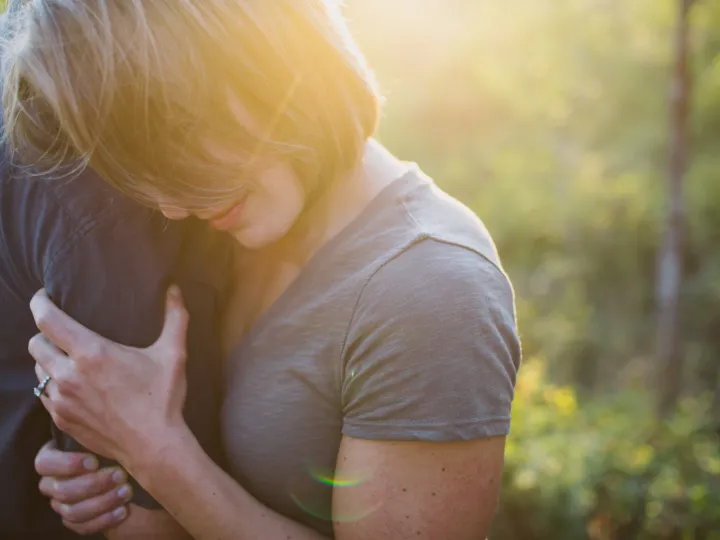 Couple embracing closely in golden hour light during an engagement session