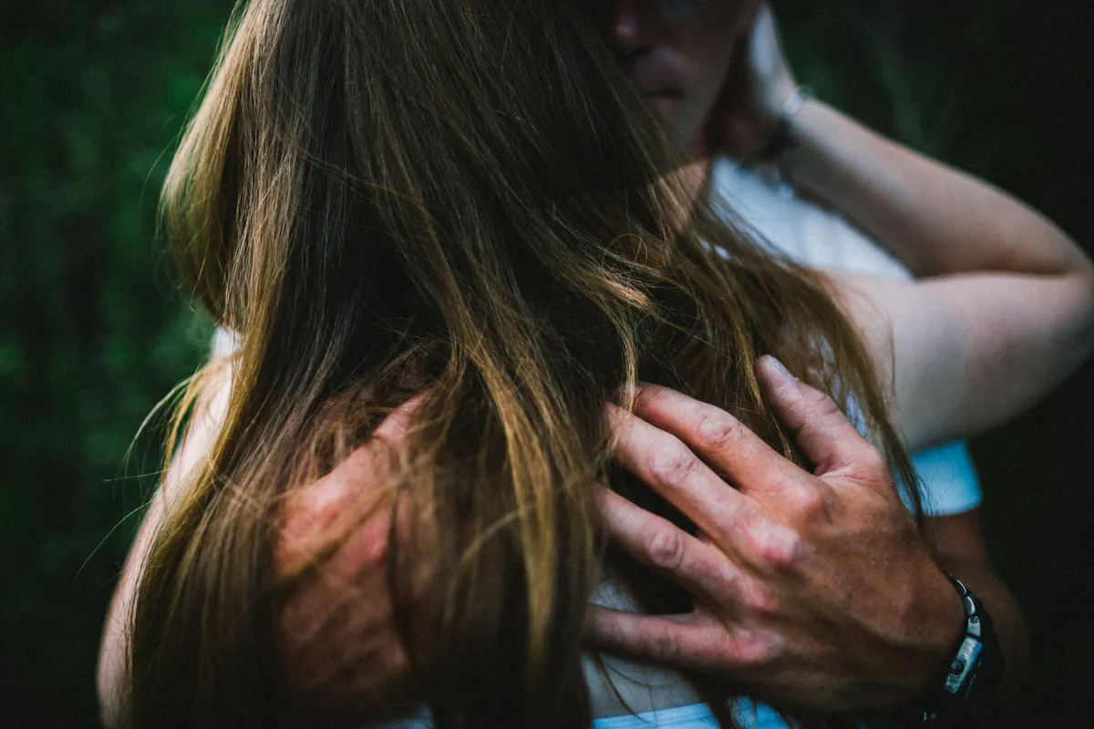 Close photo of hands resting behind a partner neck during an engagement session