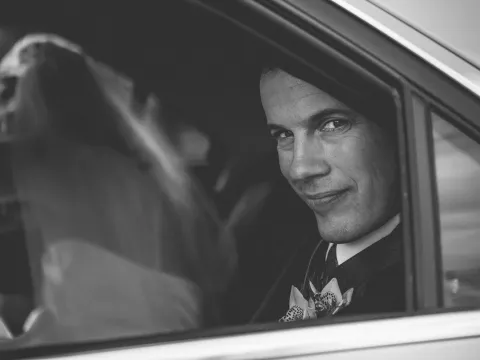 Black and white wedding photograph seen through a car window