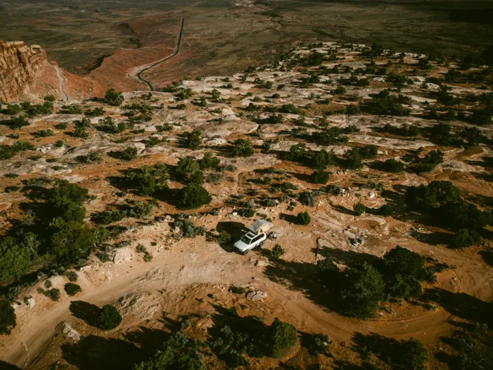 Aerial view of dry earth with winding tracks and low vegetation