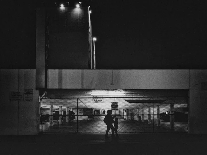 Mom moving a child through fluorescent light at night