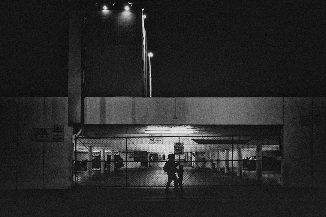 Mom moving a child through fluorescent light at night