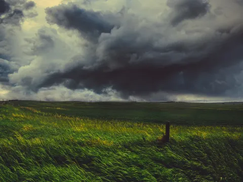 Storm clouds moving over an open prairie field