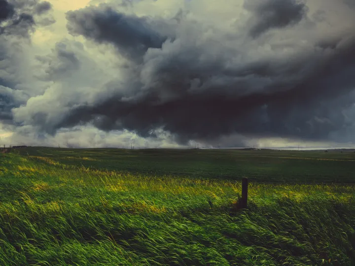 Storm clouds moving over an open prairie field