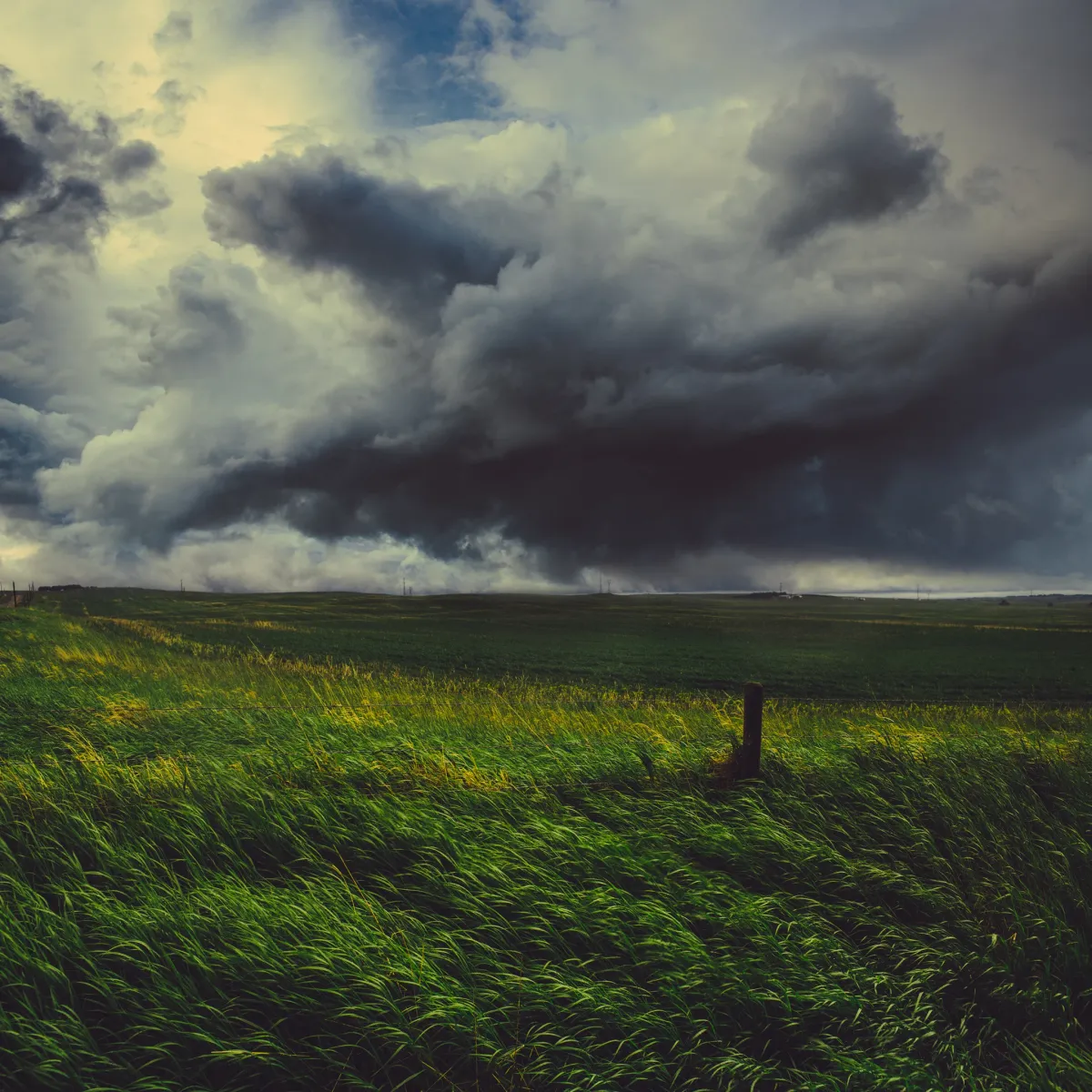 Storm clouds moving over an open prairie field