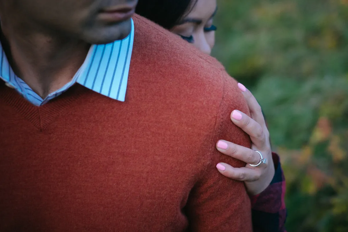 Close engagement detail of a hand resting on an orange sweater