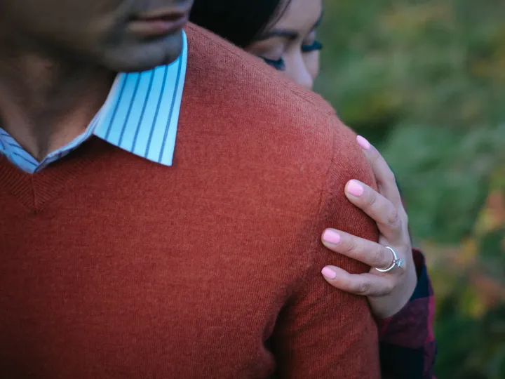 Close engagement detail of a hand resting on an orange sweater