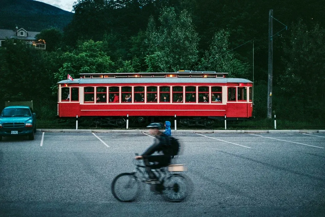 Red streetcar passing as a cyclist moves through the foreground