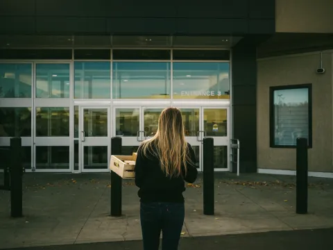 Resting Beef Face founder carrying a wooden crate toward an entrance in Alberta