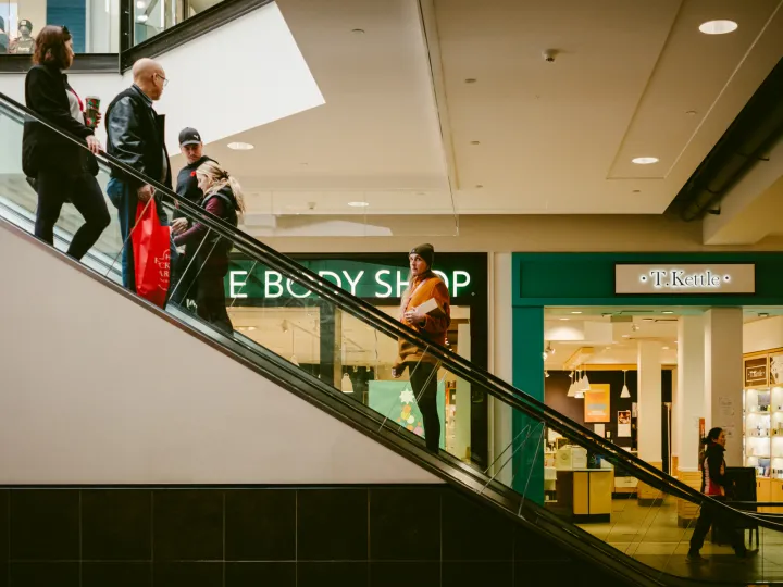 Shoppers riding an escalator inside an Edmonton mall near local retail shops