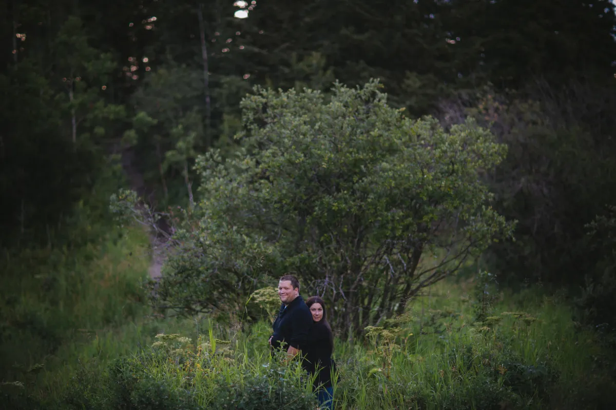 Small couple standing in a green landscape under a stormy sky