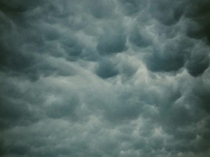 Tall storm cloud rising over a small prairie horizon