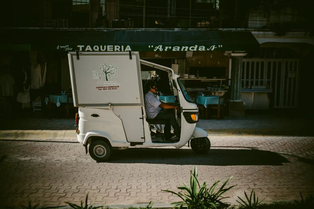White taco cart parked in warm street light with deep shade around it