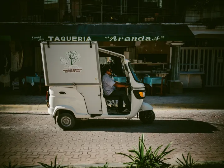 White taco cart parked in warm street light with deep shade around it
