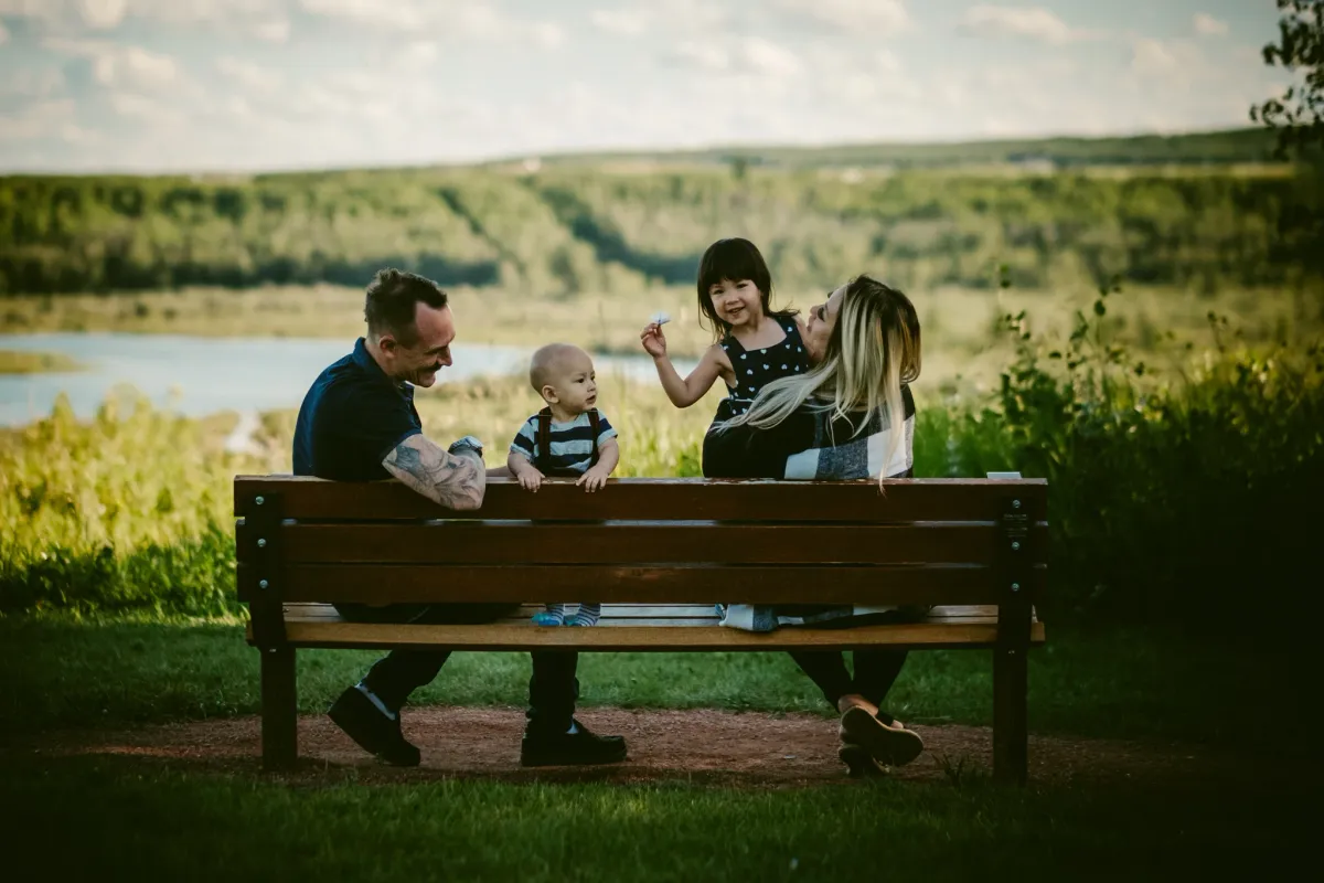 Family sitting together on a bench outdoors