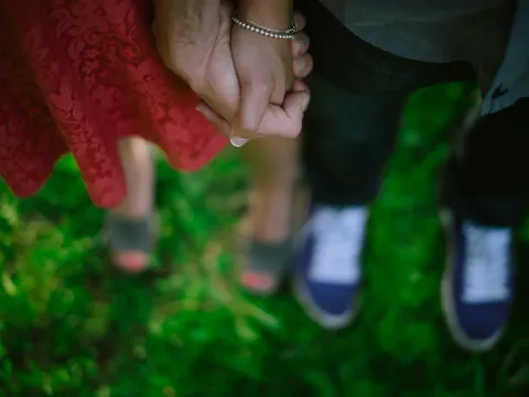 Close detail of a couple standing together in tall grass
