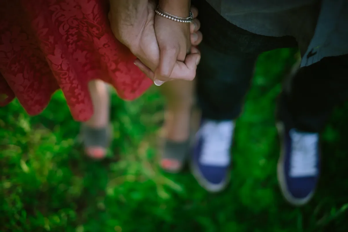 Close detail of a couple standing together in tall grass