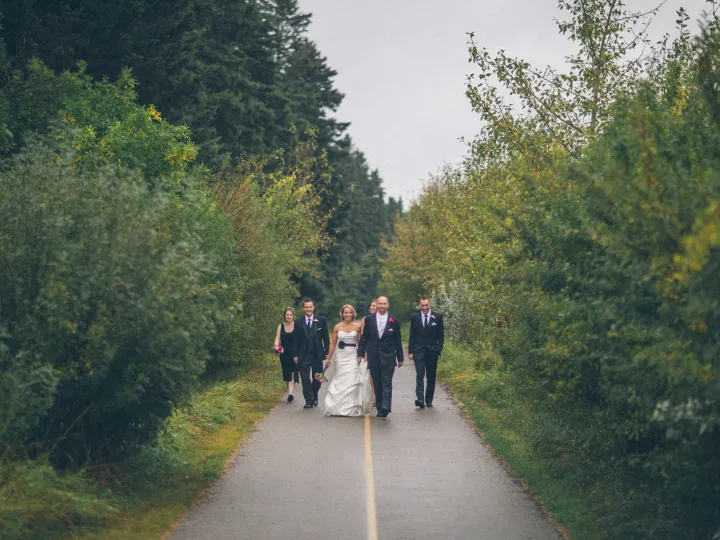 Wedding party walking together down a quiet tree-lined road