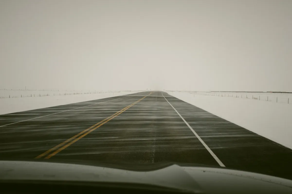 Foggy road disappearing into a pale landscape