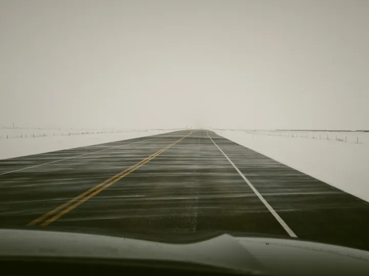 Foggy road disappearing into a pale landscape