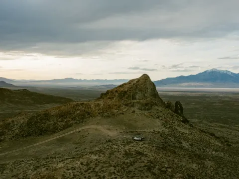 Desert ridge and road under a cloudy sky