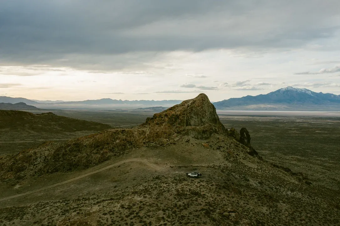 Desert ridge and road under a cloudy sky
