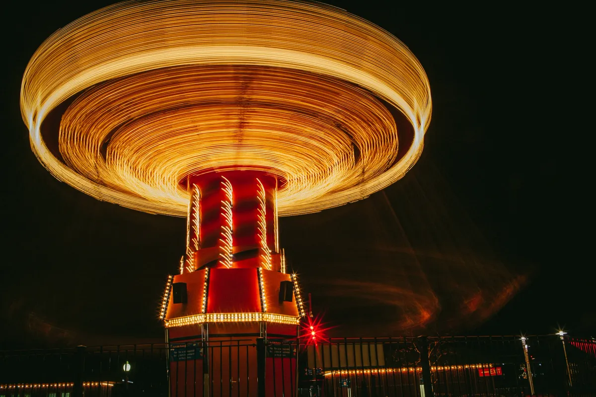 Carnival ride spinning at night with circular golden motion blur