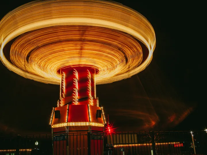 Carnival ride spinning at night with circular golden motion blur