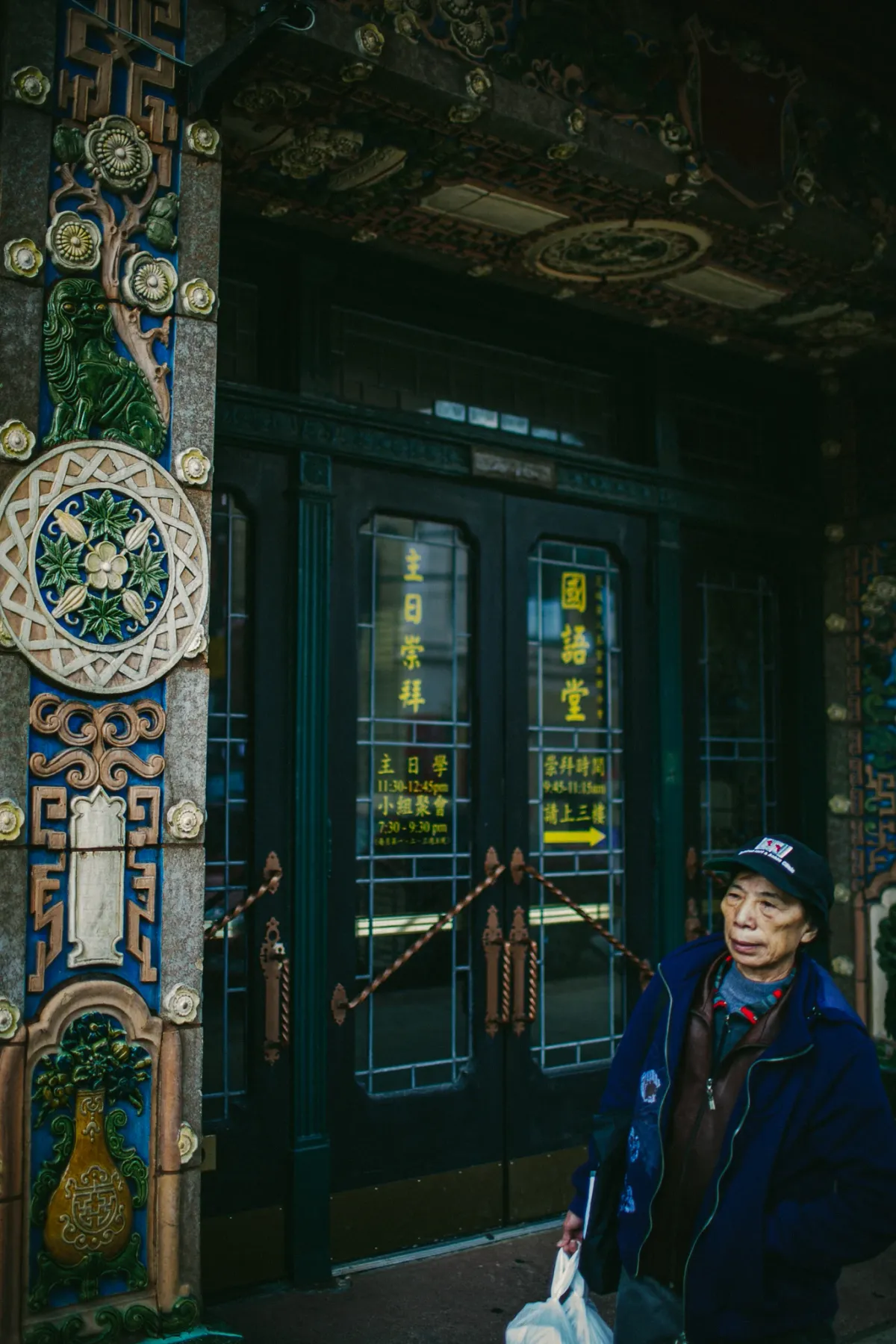 Person standing in a shaded doorway framed by patterned tile