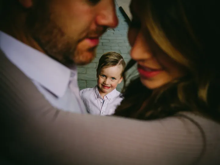 Close family portrait with a child held between parents